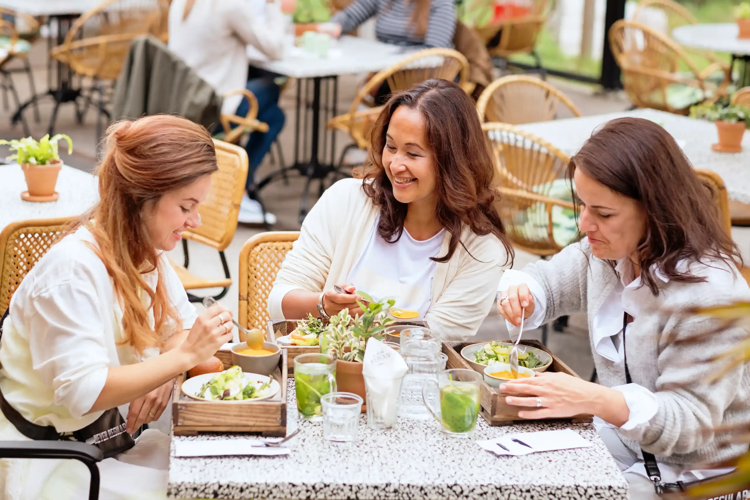 drie vrouwen aan het eten op een terras